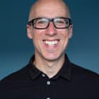 A West London wedding photographer capturing a bald man with glasses smiling for the camera.